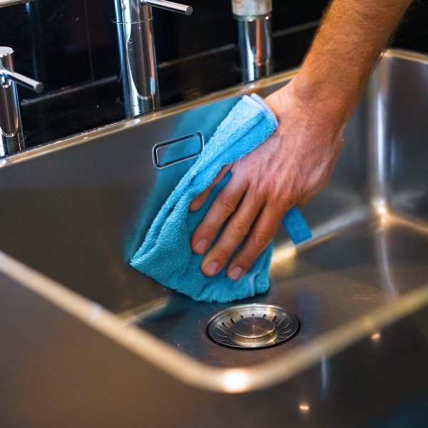 reinigen wasbak met schoonmaakdoek